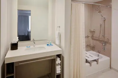 a white bathroom with a sink and a shower at Hyatt House across from Universal Orlando Resort in Orlando