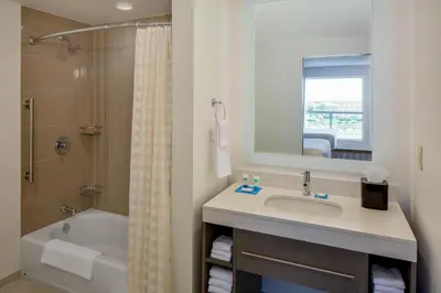 a bathroom with a sink and a tub and a shower at Hyatt House across from Universal Orlando Resort in Orlando