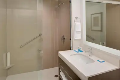 a bathroom with a sink and a shower with a mirror at Hyatt House across from Universal Orlando Resort in Orlando