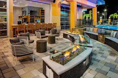 a hotel lobby with a fire pit and a bar at Hyatt House across from Universal Orlando Resort in Orlando