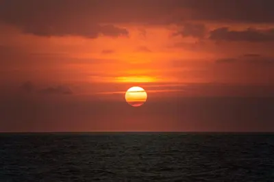 a sunset over the ocean with the sun in the sky at SPECTACULAR Home And Resort! Near Dis, Splash Park, Lake With Boats, Pool, This Home And Resort Has It ALL! Low Rates Too! in Kissimmee