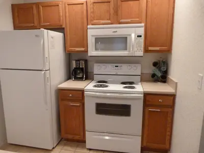 a kitchen with a white stove and a microwave at SPECTACULAR Home And Resort! Near Dis, Splash Park, Lake With Boats, Pool, This Home And Resort Has It ALL! Low Rates Too! in Kissimmee