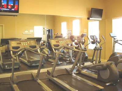 a gym with several tread machines and a mirror at SPECTACULAR Home And Resort! Near Dis, Splash Park, Lake With Boats, Pool, This Home And Resort Has It ALL! Low Rates Too! in Kissimmee