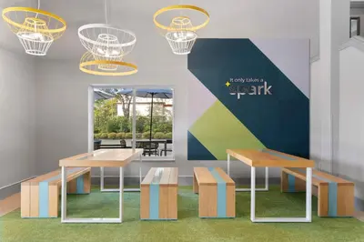 a room with two tables and benches and a sign at Spark by Hilton Orlando near SeaWorld in Orlando