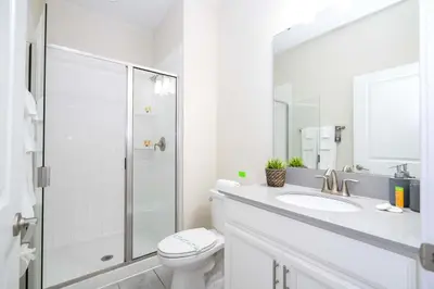 a white bathroom with a toilet and a shower at Family Friendly Four Bedrooms w/ Pool 4896 in Kissimmee