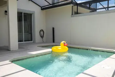 a yellow rubber duck sitting in a swimming pool at Family Friendly Four Bedrooms w/ Pool 4896 in Kissimmee
