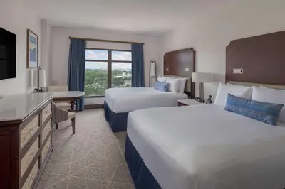 a hotel room with two beds and a window at Wyndham Grand Orlando Resort Bonnet Creek in Orlando