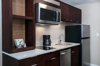 a small kitchen with a microwave and a refrigerator at TownePlace Suites by Marriott Orlando Theme Parks Lake Buena Vista in Orlando