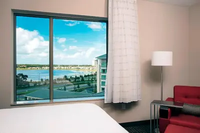 a room with a bed and a window with a view at TownePlace Suites by Marriott Orlando Theme Parks Lake Buena Vista in Orlando