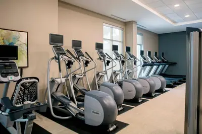 a gym with rows of exercise bikes and treadmills at TownePlace Suites by Marriott Orlando Theme Parks Lake Buena Vista in Orlando