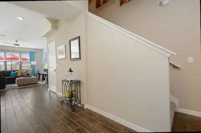 a living room with a white wall and a staircase at Family Friendly 4 Bedroom Close to Disney 5148 in Kissimmee
