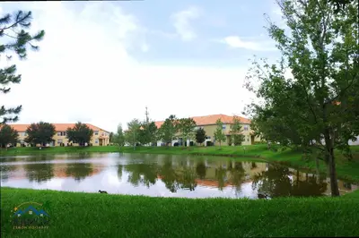 a pond in a park with buildings in the background at Family Friendly 4 Bedroom Close to Disney 5148 in Kissimmee