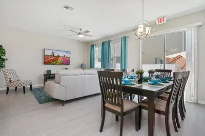 a dining room and living room with a table and chairs at Four Bedroom w/ GameRoom 5152A in Kissimmee