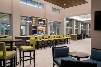 a restaurant with tables and chairs and a bar at SpringHill Suites by Marriott Orlando Theme Parks Lake Buena Vista in Orlando
