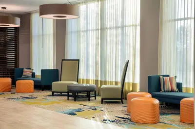 a waiting room with colorful chairs and windows at SpringHill Suites by Marriott Orlando Theme Parks Lake Buena Vista in Orlando