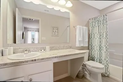 a bathroom with a sink and a toilet and a mirror at Family Friendly Four Bedrooms 5145 in Kissimmee