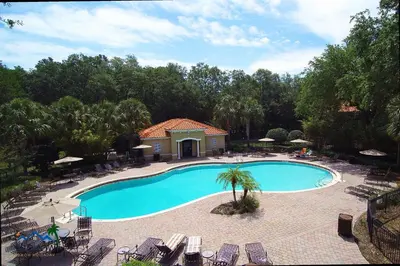 an overhead view of a swimming pool with chairs and trees at Family Friendly Four Bedrooms 5145 in Kissimmee