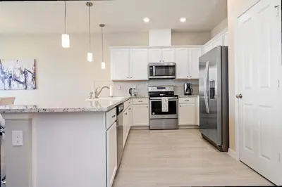 a kitchen with white cabinets and stainless steel appliances at Family Friendly Four Bedrooms 5145 in Kissimmee