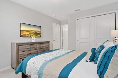 a white bedroom with a bed and a dresser at Family Friendly Four Bedrooms 5147A in Kissimmee