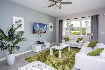 a living room with white furniture and a large window at Family Friendly Four Bedrooms 5147A in Kissimmee