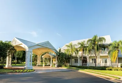 a large white house with palm trees at WorldMark Orlando Kingstown Reef in Orlando