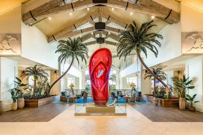 a large red surfboard in a lobby with palm trees at Margaritaville Resort Orlando with H2O Waterpark in Kissimmee
