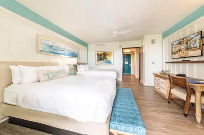 a bedroom with a large bed and a desk at Margaritaville Resort Orlando with H2O Waterpark in Kissimmee