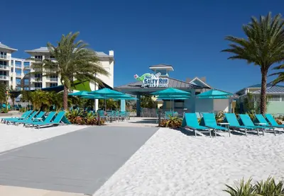 a beach with chairs and umbrellas and a resort at Margaritaville Resort Orlando with H2O Waterpark in Kissimmee