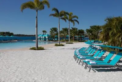 a row of blue lounge chairs on a beach at Margaritaville Resort Orlando with H2O Waterpark in Kissimmee