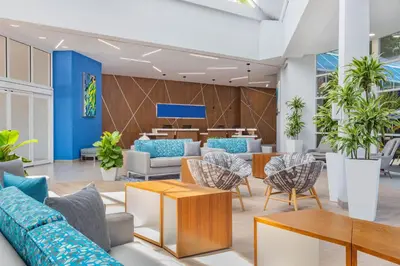 a lobby with blue and white furniture and plants at Holiday Inn Resort Kissimmee by the Parks by IHG in Orlando