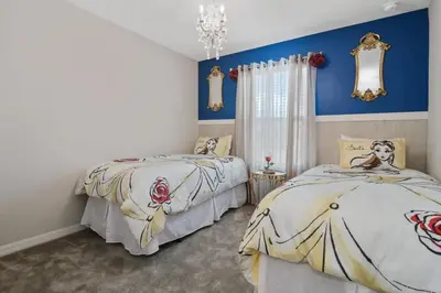 two beds in a bedroom with blue walls at Four Bedroom with GameRoom 5150A in Kissimmee
