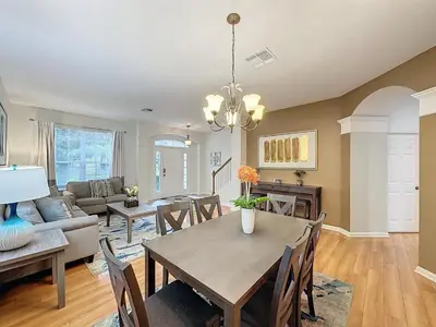 a dining room and living room with a table and chairs at Disney World Vacation.. Luxury 6 BR/4 BA 5 Star Villa in Orlando