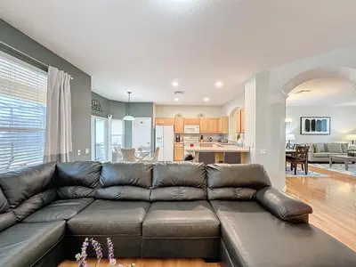 a living room with a brown leather couch at Disney World Vacation.. Luxury 6 BR/4 BA 5 Star Villa in Orlando