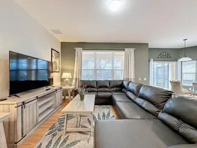 a living room with a leather couch and a flat screen tv at Disney World Vacation.. Luxury 6 BR/4 BA 5 Star Villa in Orlando