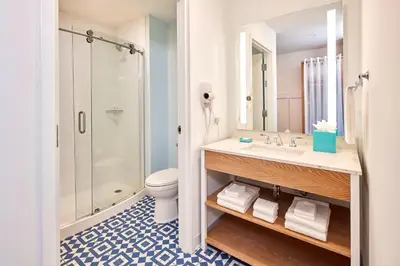 a bathroom with a sink and a shower and a toilet at Universal's Endless Summer Resort - Surfside Inn and Suites in Orlando