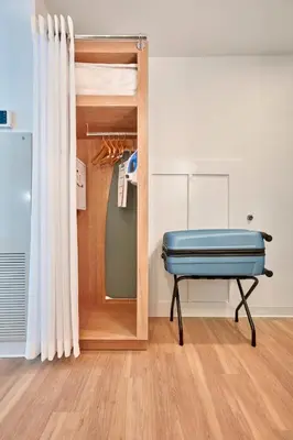 a room with a blue ottoman and a mirror at Universal's Endless Summer Resort - Surfside Inn and Suites in Orlando