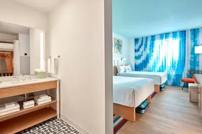 a hotel room with a bed and a bathroom at Universal's Endless Summer Resort - Surfside Inn and Suites in Orlando
