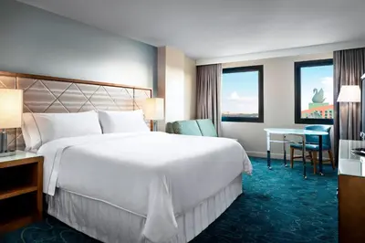 a hotel room with a large bed and a table at Walt Disney World Dolphin in Orlando