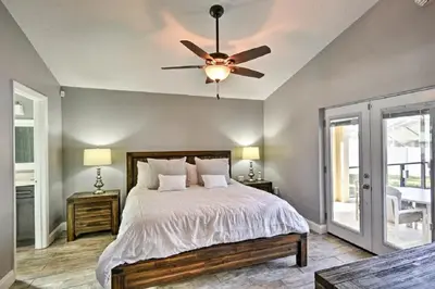 a bedroom with a bed and a ceiling fan at Mickeys Landing - Luxurious 4BR with 2 Master Suites, Privacy Fenced Pool & Hot Tub BBQ Game RM 2 miles to Disney! in Orlando