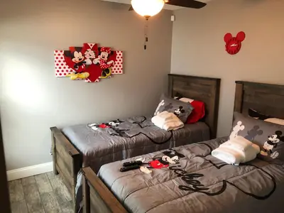 two beds in a room with stuffed animals on them at Mickeys Landing - Luxurious 4BR with 2 Master Suites, Privacy Fenced Pool & Hot Tub BBQ Game RM 2 miles to Disney! in Orlando