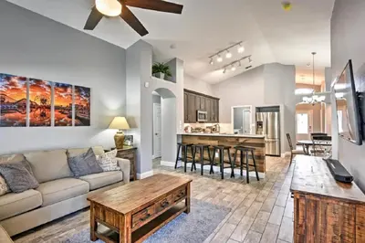 a living room with a couch and a table at Mickeys Landing - Luxurious 4BR with 2 Master Suites, Privacy Fenced Pool & Hot Tub BBQ Game RM 2 miles to Disney! in Orlando