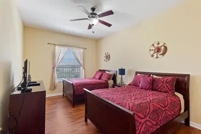 a bedroom with a bed and a couch and a ceiling fan at Executive 3 Bedroom Villa at Universal,Convention Center, Vista Cay in Orlando