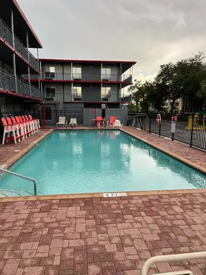 a large swimming pool in front of a building at Travelodge by Wyndham Orlando at Heart of International Drive in Orlando