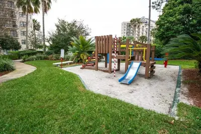 a playground with a slide in a park at Enclave Apartments at International Drive in Orlando