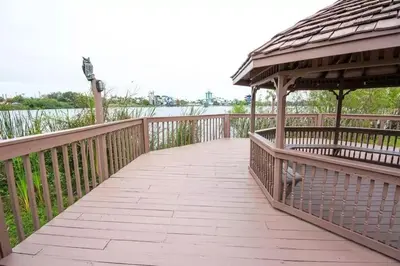 a wooden boardwalk with a gazebo and the water at Enclave Apartments at International Drive in Orlando