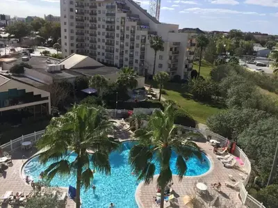 an overhead view of a large swimming pool with palm trees at Enclave Apartments at International Drive in Orlando