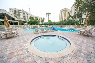 a large swimming pool with chairs and umbrellas at Enclave Apartments at International Drive in Orlando