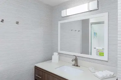 a white bathroom with a sink and a mirror at Home2 Suites By Hilton Orlando South Park - Near Epic Universe in Orlando