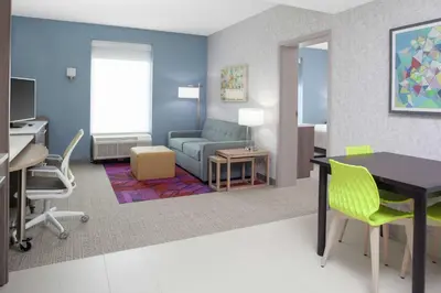 a rendering of a living room with a desk and a couch at Home2 Suites By Hilton Orlando South Park - Near Epic Universe in Orlando