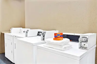 a row of white washing machines in a room at Super 8 by Wyndham Kissimmee/Maingate/Orlando Area in Orlando